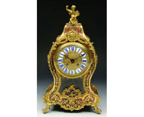 A FRENCH RED TORTOISESHELL AND BRASS INLAID CLOCK with blue enamel numerals and rococo scroll and cherub ornament, the striki