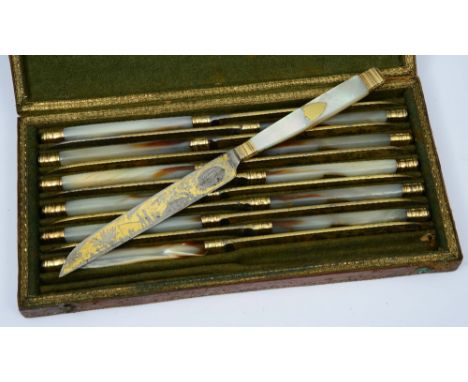 A SET OF TWELVE GILT METAL AND MOTHER OF PEARL HANDLED KNIVES with blade, decorated with hunting and travelling scenes, 20cm 