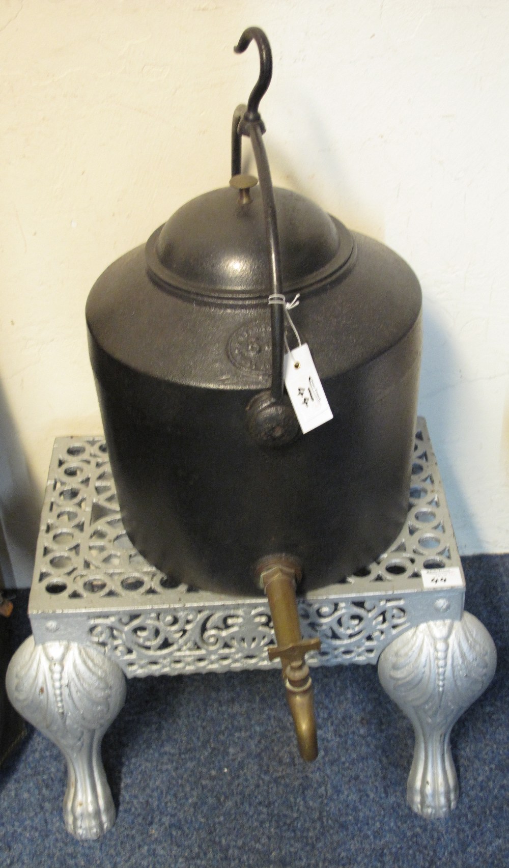 Large cast iron hanging kettle with brass tap together with a cast