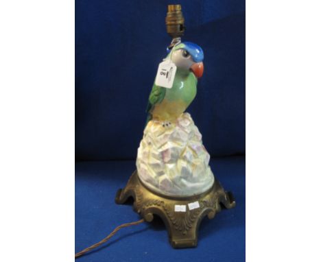 Pottery lamp base in the form of a multicoloured parrot on rockwork with yellow metal support.  43cm high.