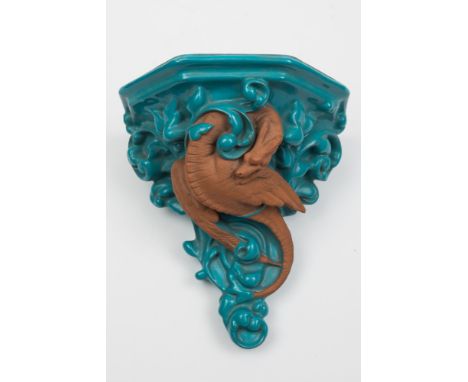 A Watcombe (Torquay) pottery wall bracket: modelled in the form of a dragon writhing amongst turquoise foliage, printed Watco