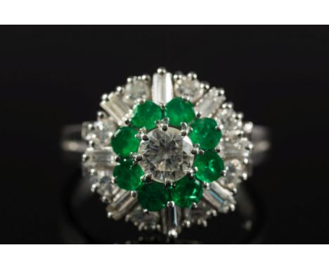 An emerald and diamond circular cluster ring:, the principal brilliant-cut diamond estimated to weigh 0.45ct, within a surrou