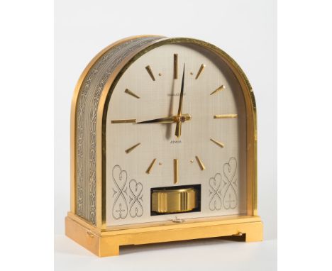 An unusual Jaeger-Le Coultre Atmos clock:, the arched silvered dial having brass dauphaine and baton hour markings, brass dau