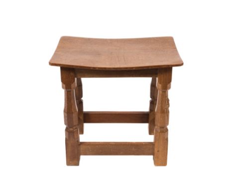 By Robert Thompson of Kilburn - A 'Mouseman' oak stool:, the adzed curved seat on polygonal legs, one being carved with a mou