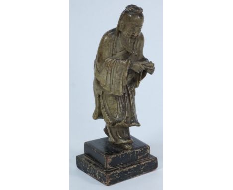 A Chinese carved soapstone figure of a smiling Immortal: wearing flowing robes and holding a scroll, late 18th/early 19th cen