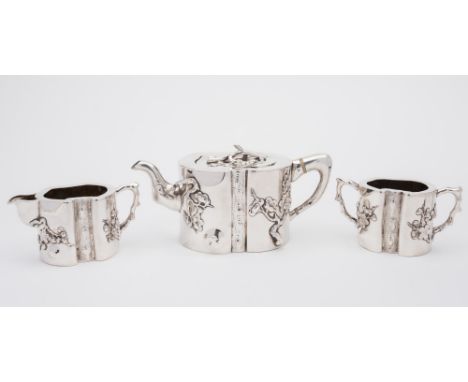 A Chinese silver three-piece tea service, maker KC:  of ovoid outline with prunus blossom and foliate decoration, 34.68ozs.
