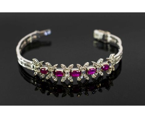 A RUBY AND DIAMOND BRACLET, set with five oval shaped rubies with emerald cut diamonds set between and brilliant diamond term