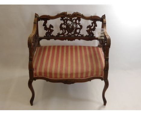 A Victorian Window Seat, with decorative carving to back panel and arm rest, on splayed feet, approx 60 x 45 x 68 cms.(AF)