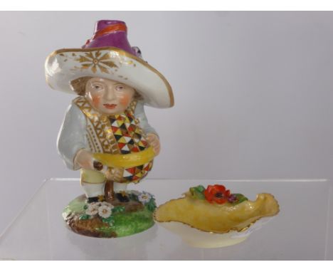 A Porcelain Mansion House Dwarf, depicted wearing a bold waistcoat and a lavender hat, with red pseudo Derby mark to base, ap