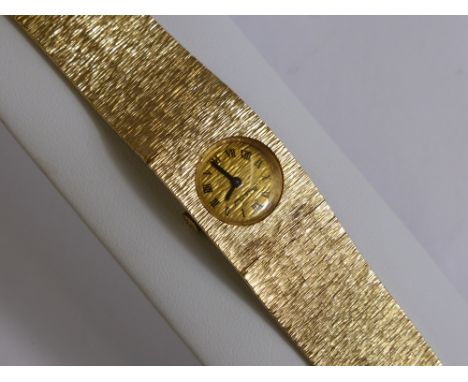 A Lady's 9 Ct Gold Vintage  Beuche Girod Wrist Watch, the watch having a 9 ct bark finish integral bracelet with gold face an