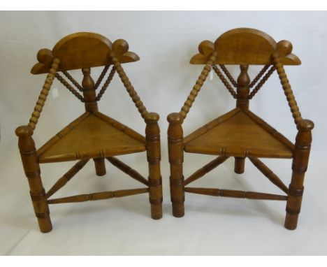 A Pair of Oak Turner Chairs in 17th Century Style with triangular seats and bobbin arm rests, turned supports and stretchers,