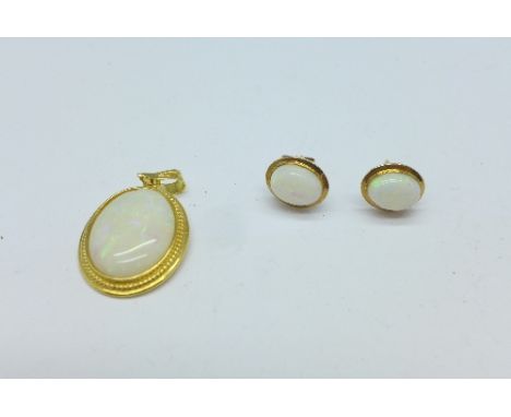 An 18ct gold and opal pendant and a pair of yellow metal and opal earrings