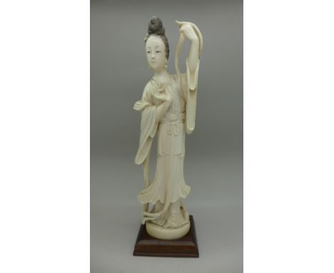 An early 20th Century carved ivory figure of a lady, on a wooden stand, 22cm