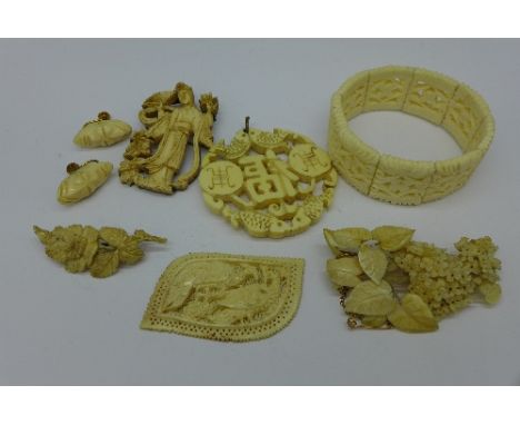 A carved ivory pendant, three carved brooches, etc.