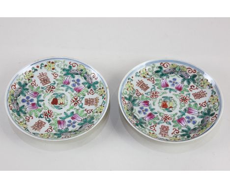 A pair of Chinese famille rose porcelain saucers, decorated with character symbols, butterflies, and fruiting and blossoming 