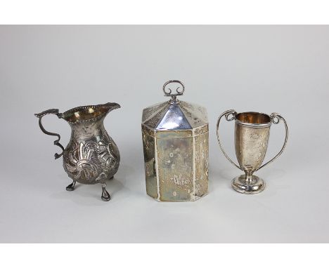 An Edward VII silver tea caddy with domed lid, Birmingham 1909, 12cm, (a/f), an embossed silver cream jug with scroll handle,