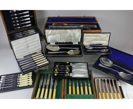 An oak cased three-piece carving set, with horn handles, a cased set of six dessert knives and forks with mother of pearl han