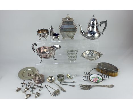 A silver plated sarcophagus shaped tea caddy, a small Queen Anne style teapot, sauce boat, two pairs of knife rests, toast ra