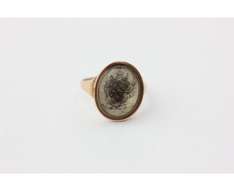 A George III gold ring, engraved with a coat of arms and motto on the reverse with a monogram