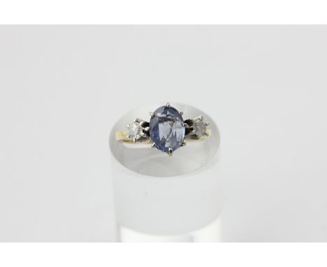 A sapphire and diamond three-stone ring, the oval cut stone with round diamonds to each shoulder