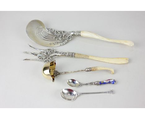 A pair of Sterling silver servers, fork and slice with cast scroll decoration, a matching sterling silver gilt sauce ladle, a