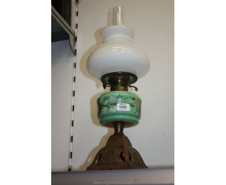 A Brass Oil lamp and shade having green reservoir and opaque shade.