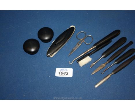 The contents of an early 20th c. Necessaire to include; rough pots, nail buffer, button hooks, etc., all in Ebony.