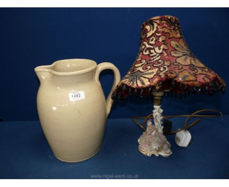 A large cream Doulton Lambeth stoneware Jug and a Dresden table lamp with seated lady in lace dress and having attractive bea