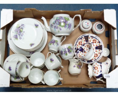 A part Teaset decorated with violets comprising teapot, milk jug, three bread and butter plates, thirteen side plates, twelve