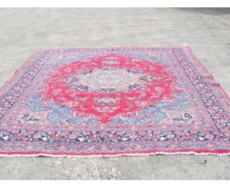 A large red ground Iranian Carpet, 385 cm x 293 cm. with label to rear, style no. 32945