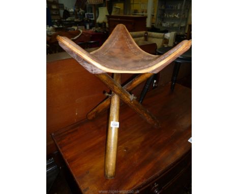 A triangular leather seated Stool with folding action, 19'' high x 14 1/2'' wide