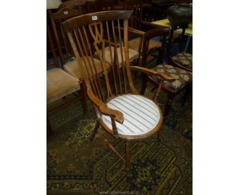 An Arts and Crafts style satinwood Elbow Chair having turned legs and arm supports, stick back with fretworked central splat,