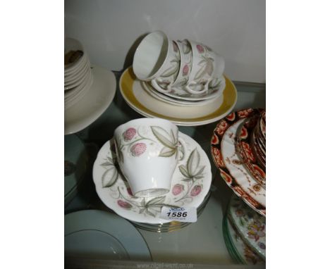 A quantity of Susie Cooper 'Wild Strawberry' tea cups and saucers, along with two Sunflower plates.