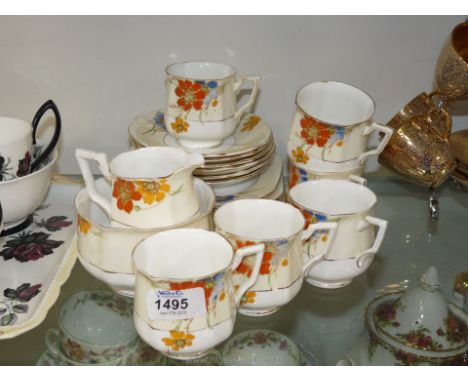 A part Bell china Teaset including six cups, saucers and tea plates, hand painted with red and yellow flowers (worn).