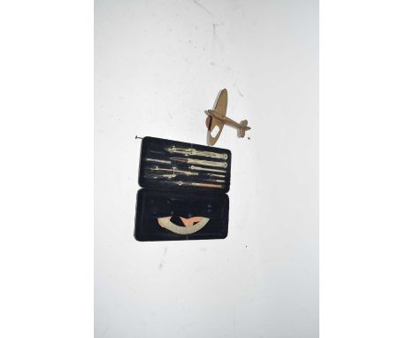 Cased set of vintage drawing instruments and a small desk ornament formed as a WW2 aeroplane