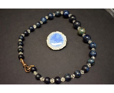 A blue ceramic brooch; together with a blue stone and glass bead necklace. 