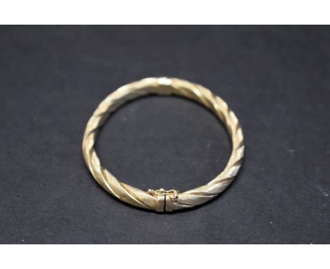 An engine turned 9ct gold bangle, 10g. 