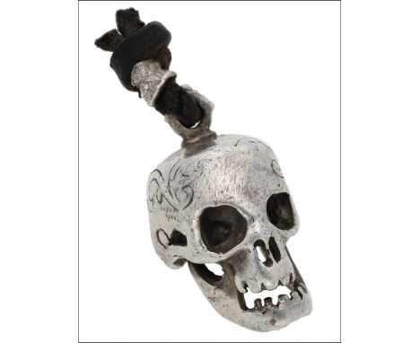 A silver skull pendant, 1986, realistically modelled, with hinged jaw and scroll engraved detail to the crown, Birmingham hal