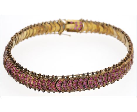An Indian ruby collar necklace, comprised of crescent-shaped links within a wire frame, each link set with three graduated ca