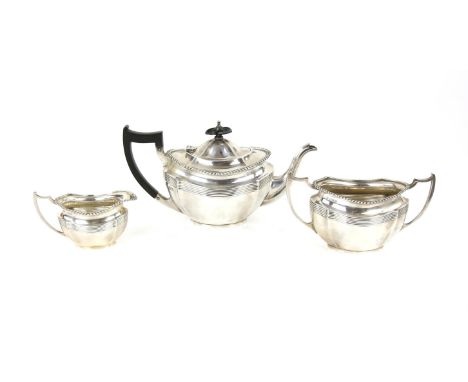 George V silver three piece tea service, Chester 1911, of serpentine form with ebonised handle and knob, comprising teapot,  