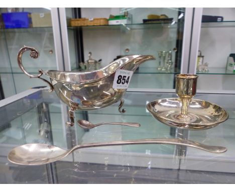 A HALLMARKED SILVER SAUCEBOAT, TWO SMALL CONDIMENT SPOONS AND A TIFFANY SILVER PLATED TAPER CANDLESTICK. 