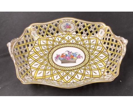 A Dresden oval pierced basket, the central cartouche painted with a basket of summer flowers, within a lattice of yellow and 