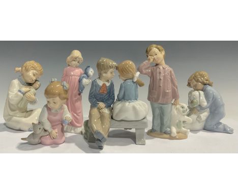 A Nao Lladro figural group of a young girl and boy on a bench, 16cm high; a Nao Llado figure of a young boy with a teddy bear