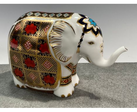 A Royal Crown Derby paperweight, Elephant, printed in the 1128 pattern, trunk raised, gold stopper, 10cm, printed marks 