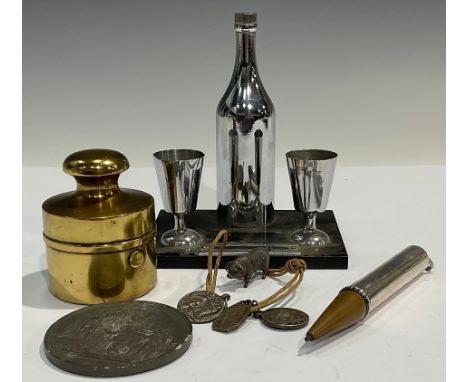 An Art Deco novelty cocktail bar table lighter; a silver propelling pencil; an early 20th century brass novelty travelling in