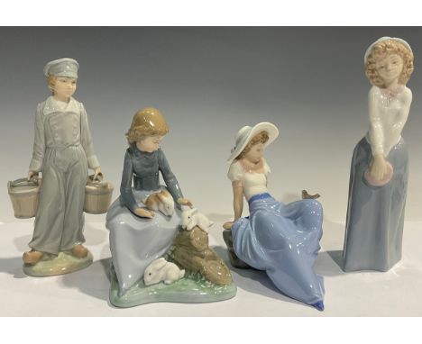 A Nao Lladro figural group of a young girl perched upon logs beside Rabbits, 18cm high; other Nao Lladro figures (4) 