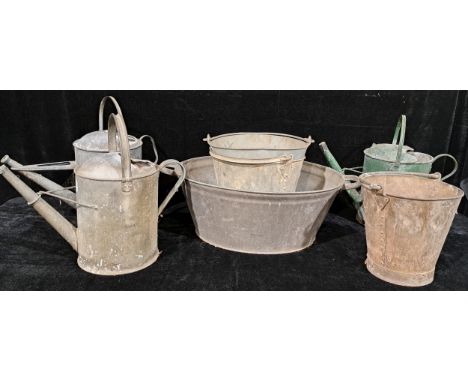 A rivetted galvanised steel bucket; others; galvanised steel watering cans; a two handled wash basin (7) 