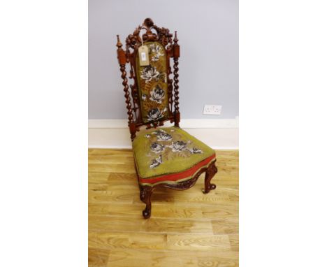 A Victorian mahogany prie dieu having a carved top over a beadwork padded back support flanked by barley twist supports above