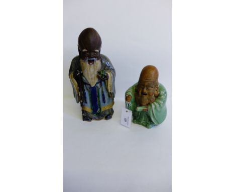 Chinese stoneware and Shiwan type glazed figure of a sage modelled standing holding a piece of fruit together with another sm