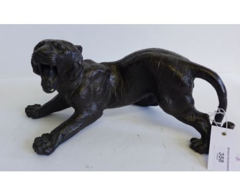 A bronze model of a tiger, modelled in roaring pose, with a textured finish, 36cm long